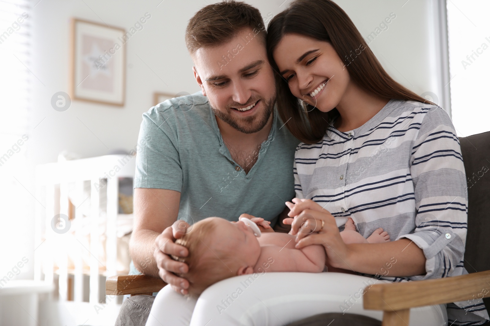 Photo of Happy couple with their newborn baby at home