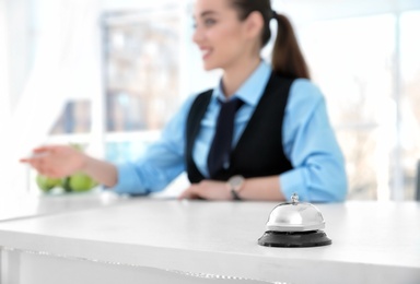 Service bell and female receptionist in hotel