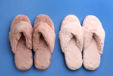 Photo of Different stylish soft slippers on blue background, flat lay