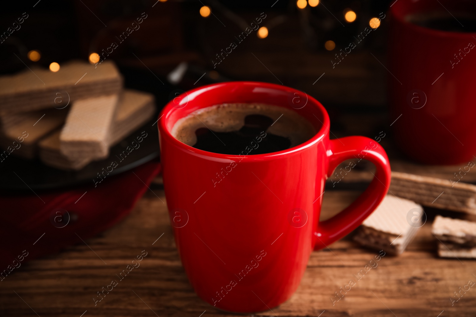 Photo of Delicious coffee and wafers on wooden table