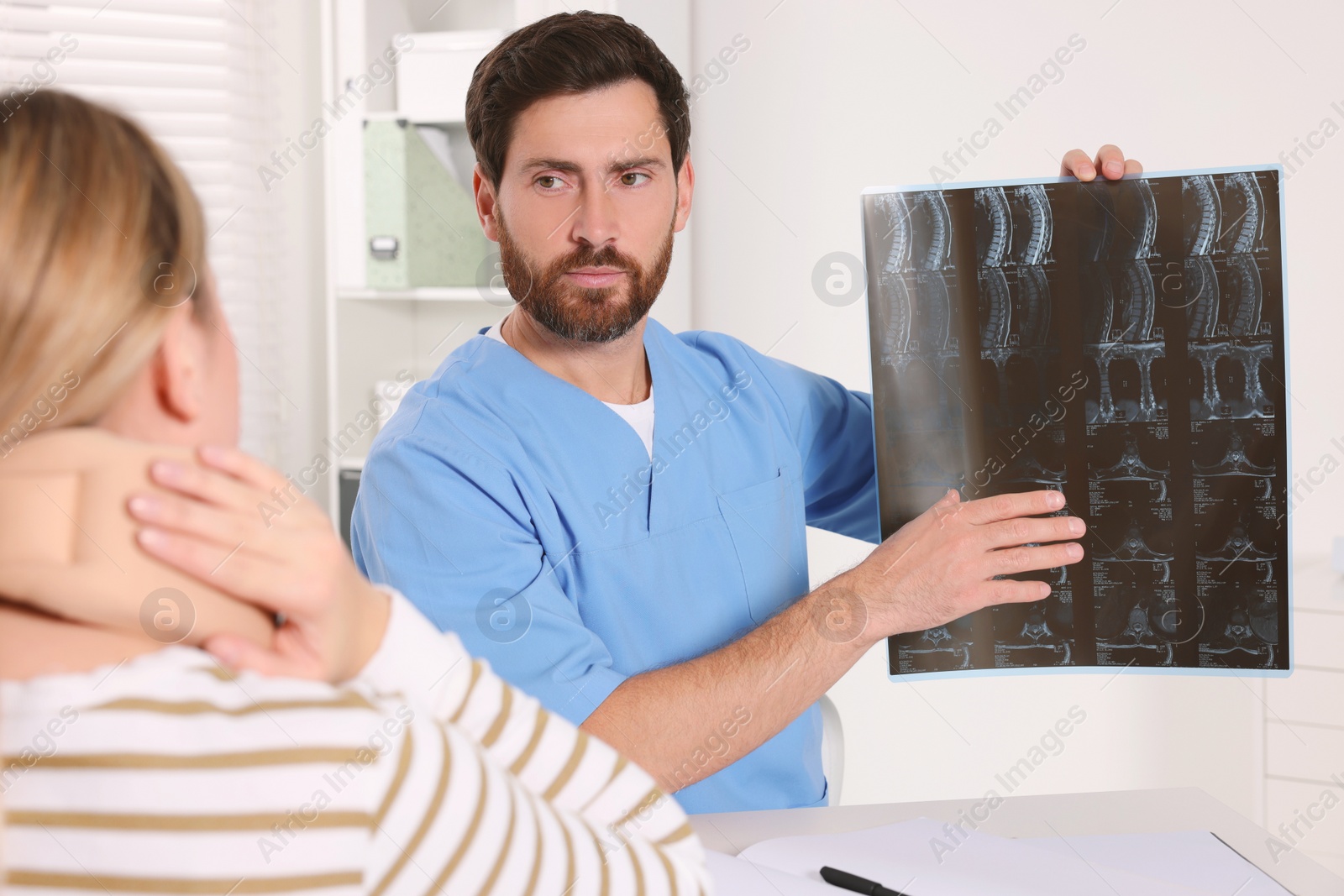 Photo of Doctor with neck MRI scan consulting patient in hospital