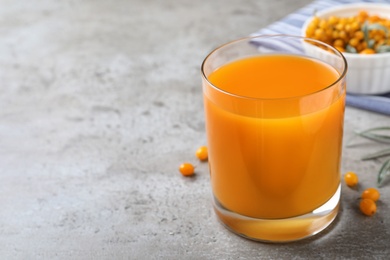 Delicious sea buckthorn juice on grey table. Space for text