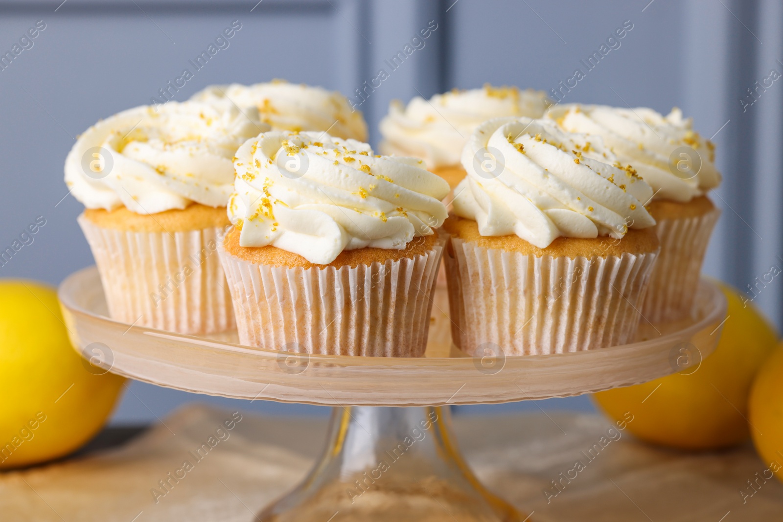 Photo of Delicious lemon cupcakes with white cream on table, closeup