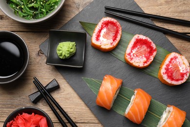 Photo of Flat lay composition with delicious sushi rolls on wooden table