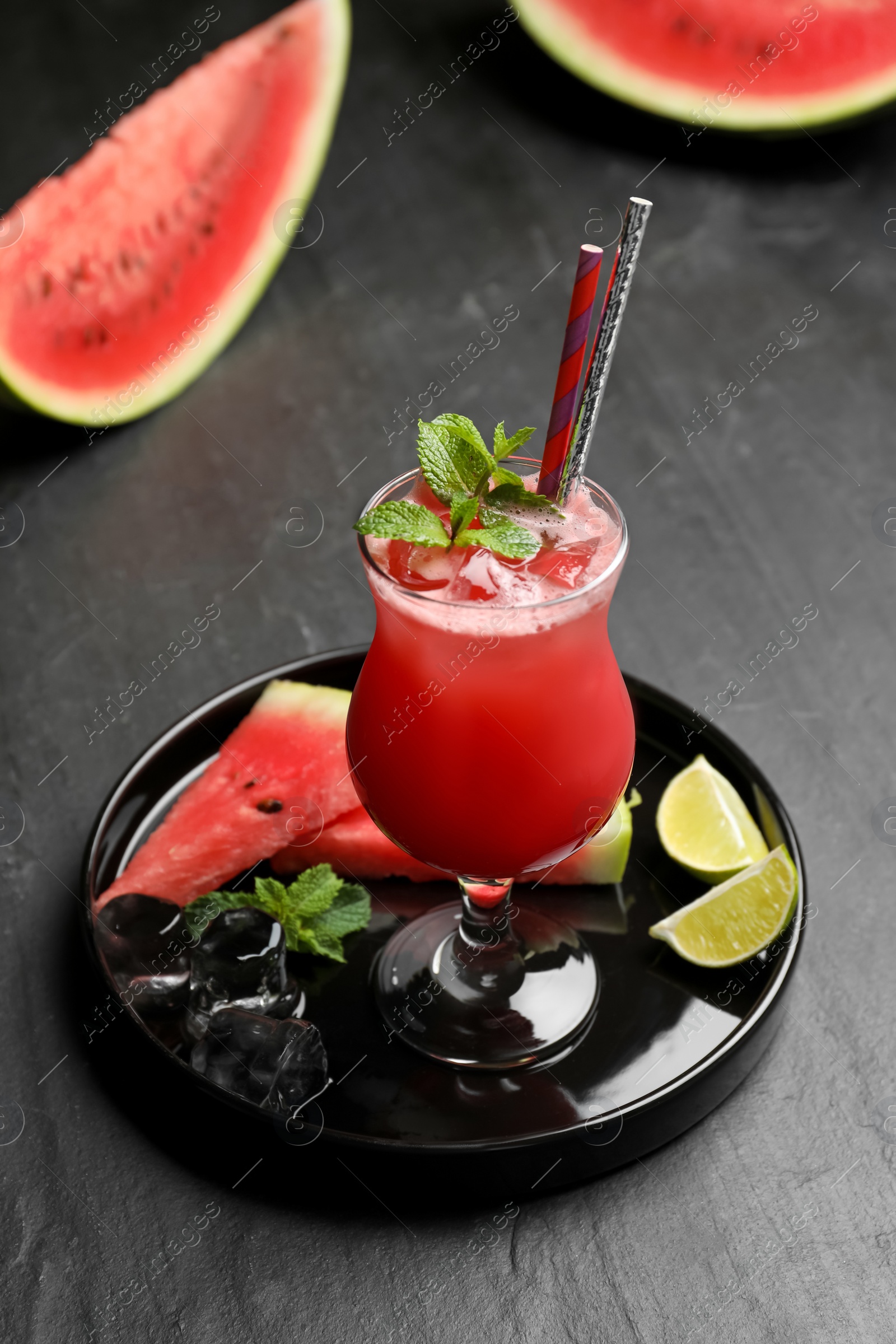 Photo of Tasty watermelon drink with mint on black table