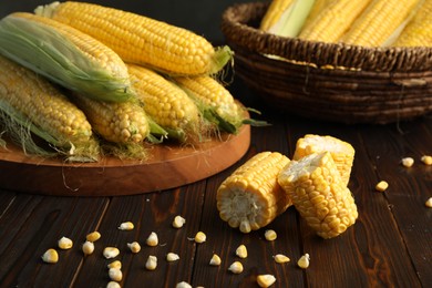 Tasty sweet corn cobs on wooden table