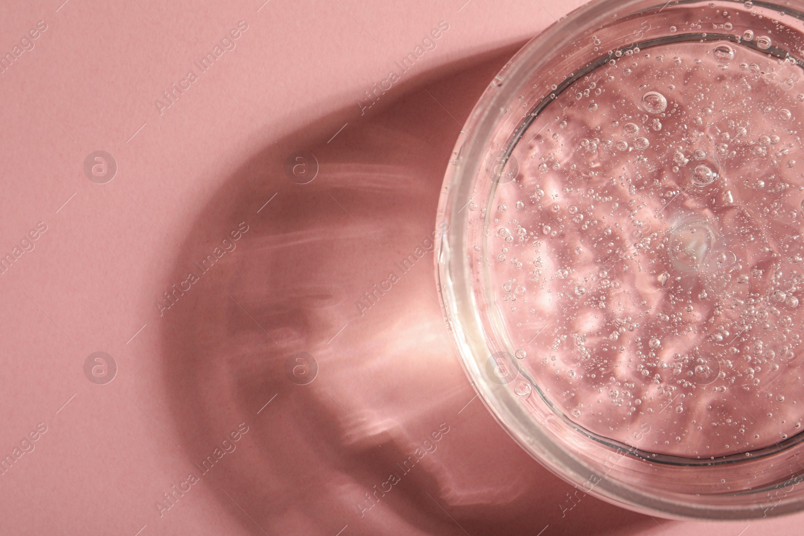 Photo of Jar of cosmetic gel on pink background, top view. Space for text
