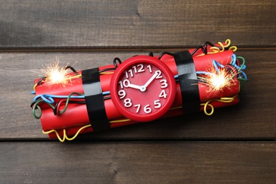 Photo of Dynamite time bomb on wooden table, top view