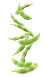 Many green edamame pods falling on white background