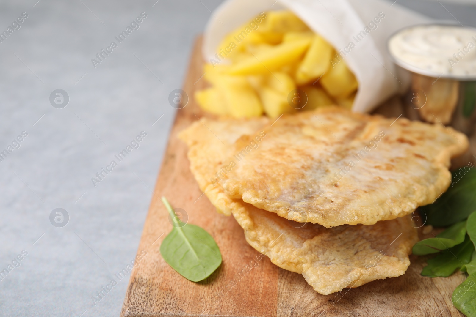 Photo of Delicious fish and chips with mangold on gray table, closeup. Space for text