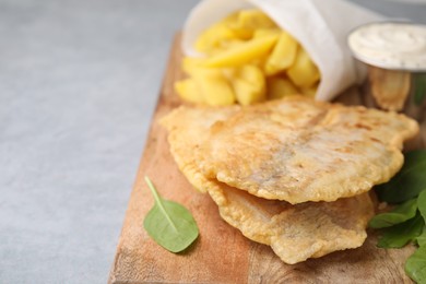 Delicious fish and chips with mangold on gray table, closeup. Space for text