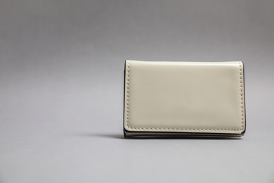 Photo of Stylish leather purse on light grey background. Space for text