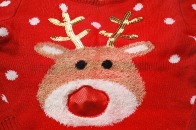 Photo of Warm red Christmas sweater with deer as background, closeup view