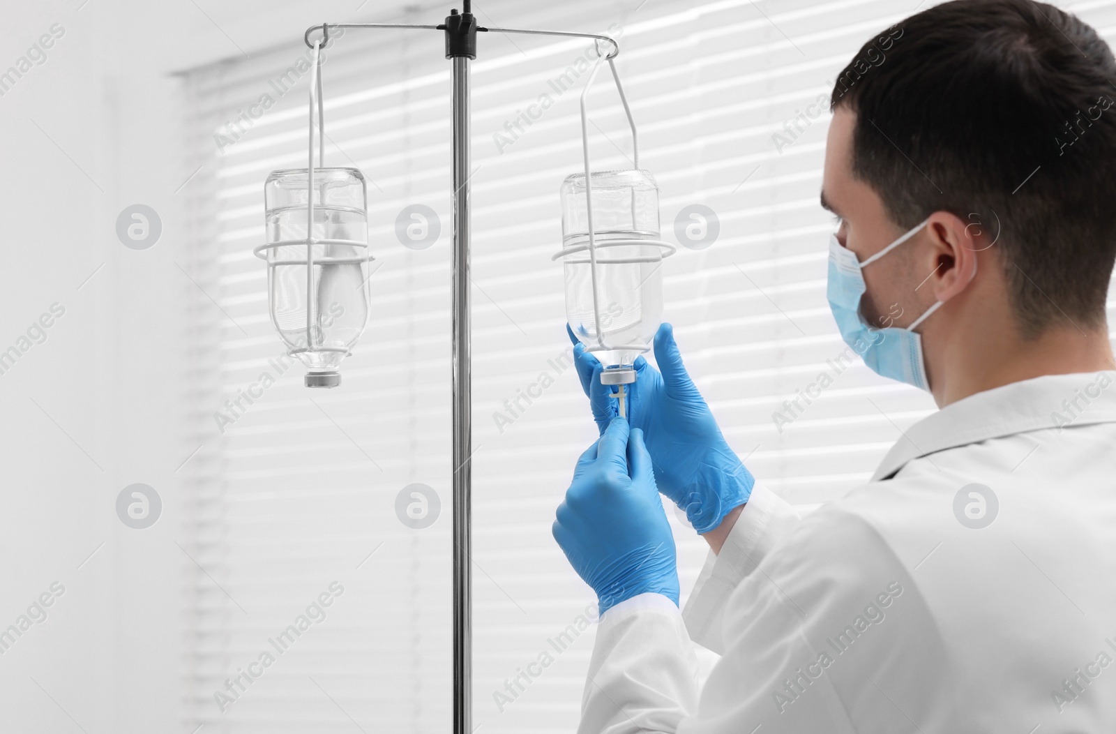 Photo of Doctor setting up IV drip in hospital