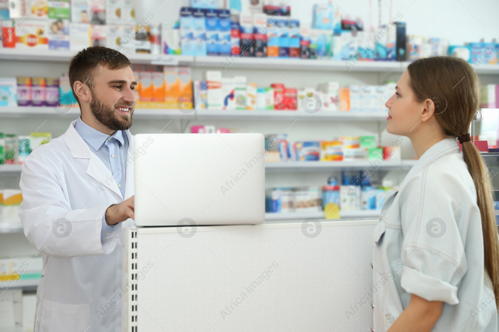 Photo of Professional pharmacist working with customer in modern drugstore