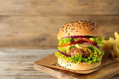 Photo of Burger with delicious patty on wooden table, space for text