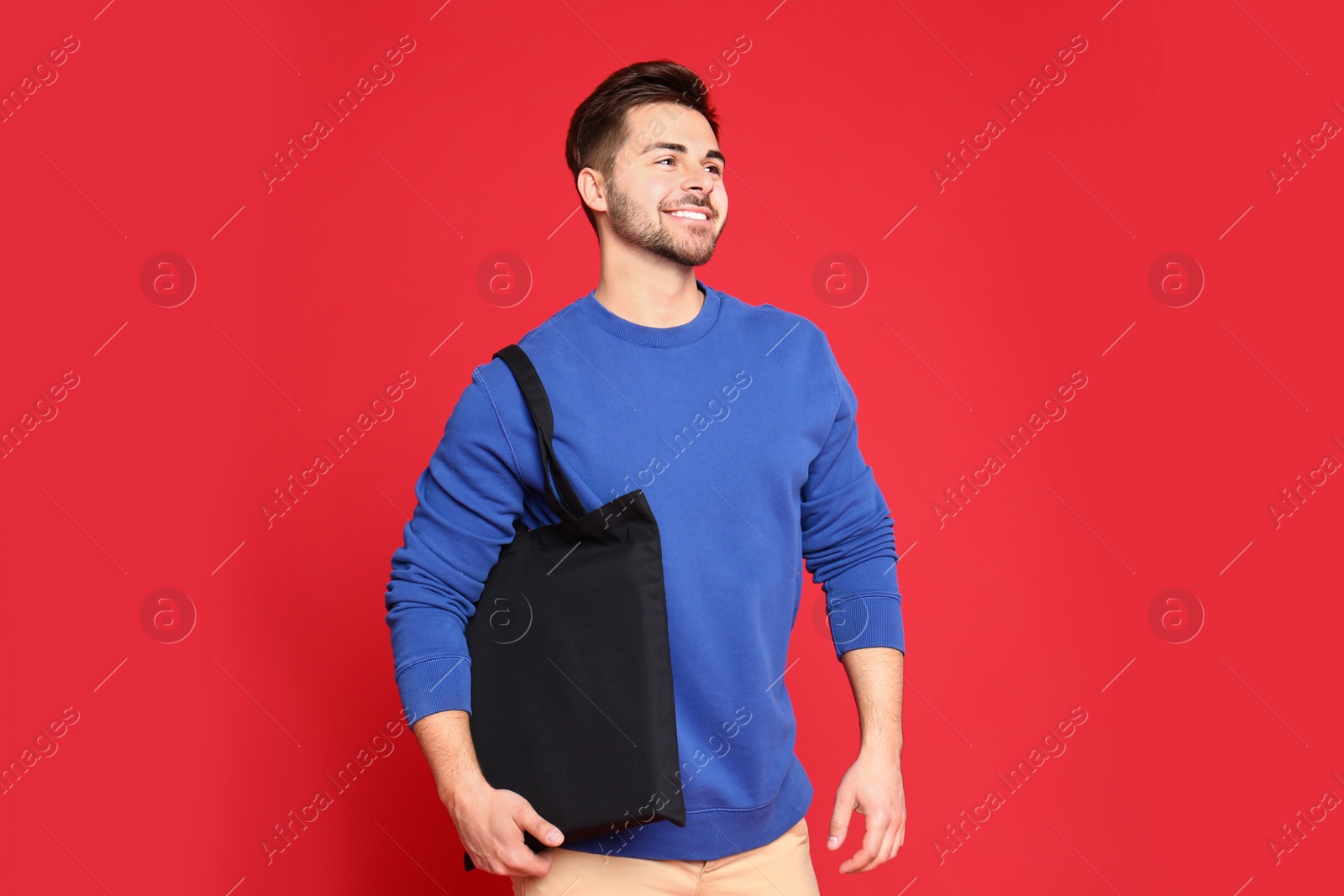 Photo of Portrait of young man with eco bag on red background