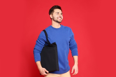 Photo of Portrait of young man with eco bag on red background
