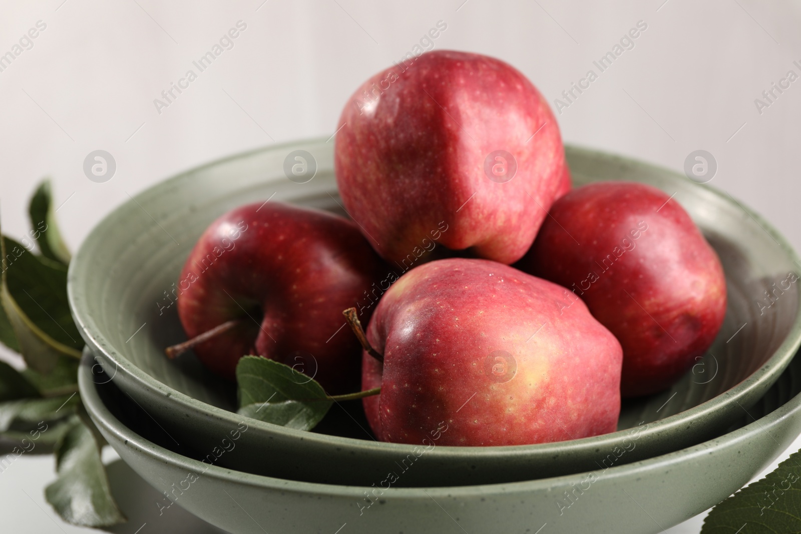 Photo of Fresh red apples and leaves on table, closeup