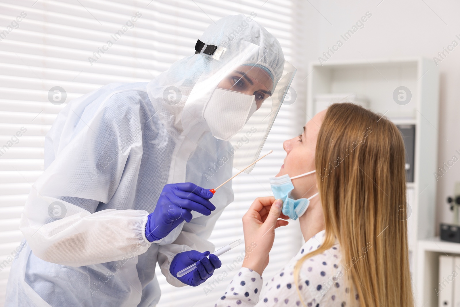 Photo of Laboratory testing. Doctor in uniform taking sample from patient's nose with cotton swab at hospital