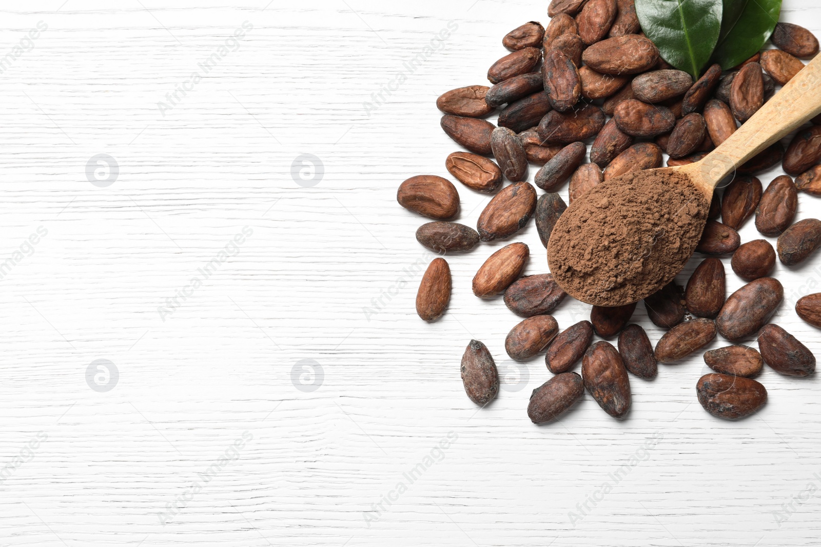 Photo of Flat lay composition with cocoa beans and powder on white wooden table, space for text