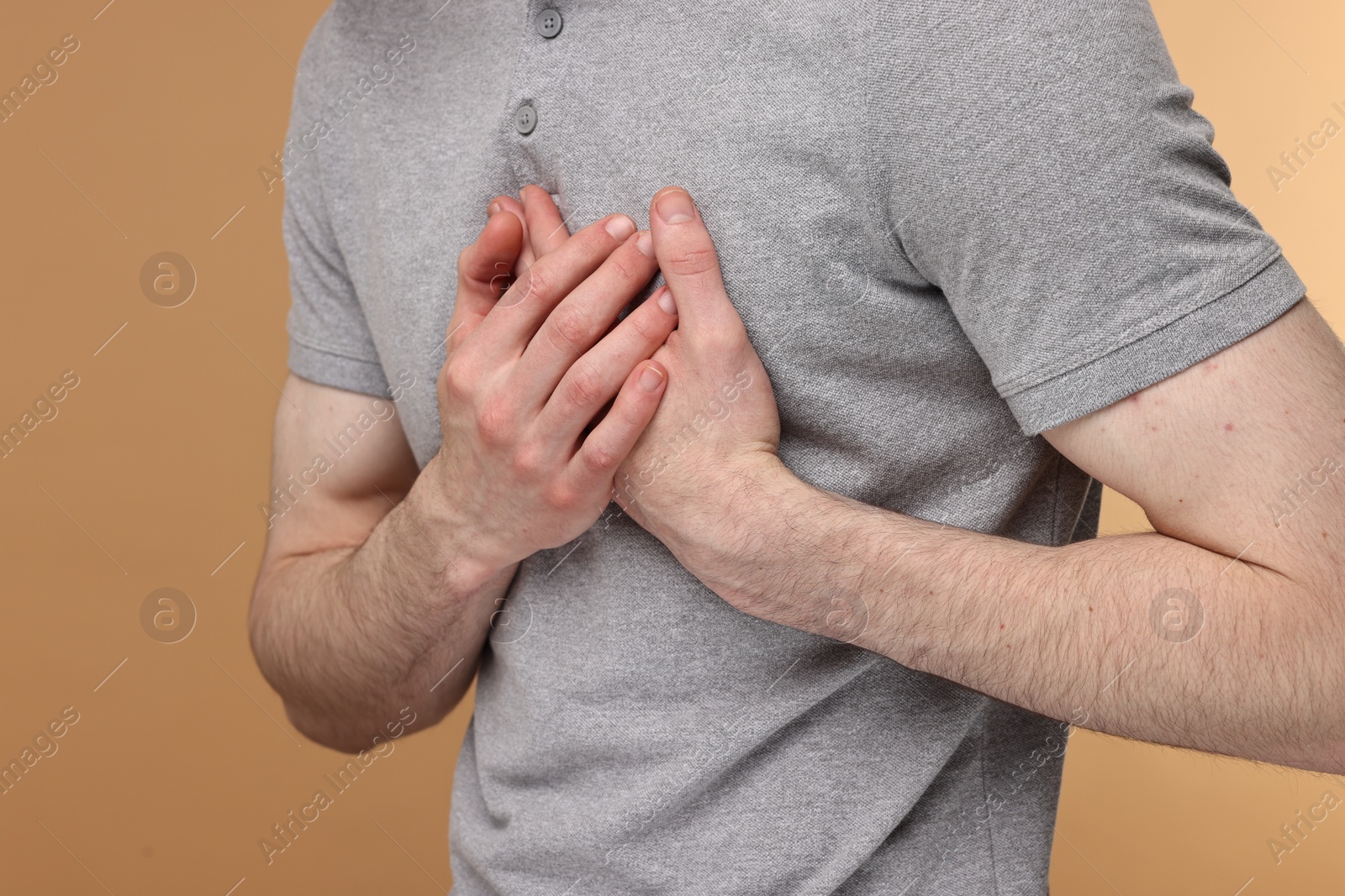 Photo of Man suffering from heart hurt on beige background, closeup