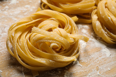 Photo of Tagliatelle pasta on wooden board, closeup view