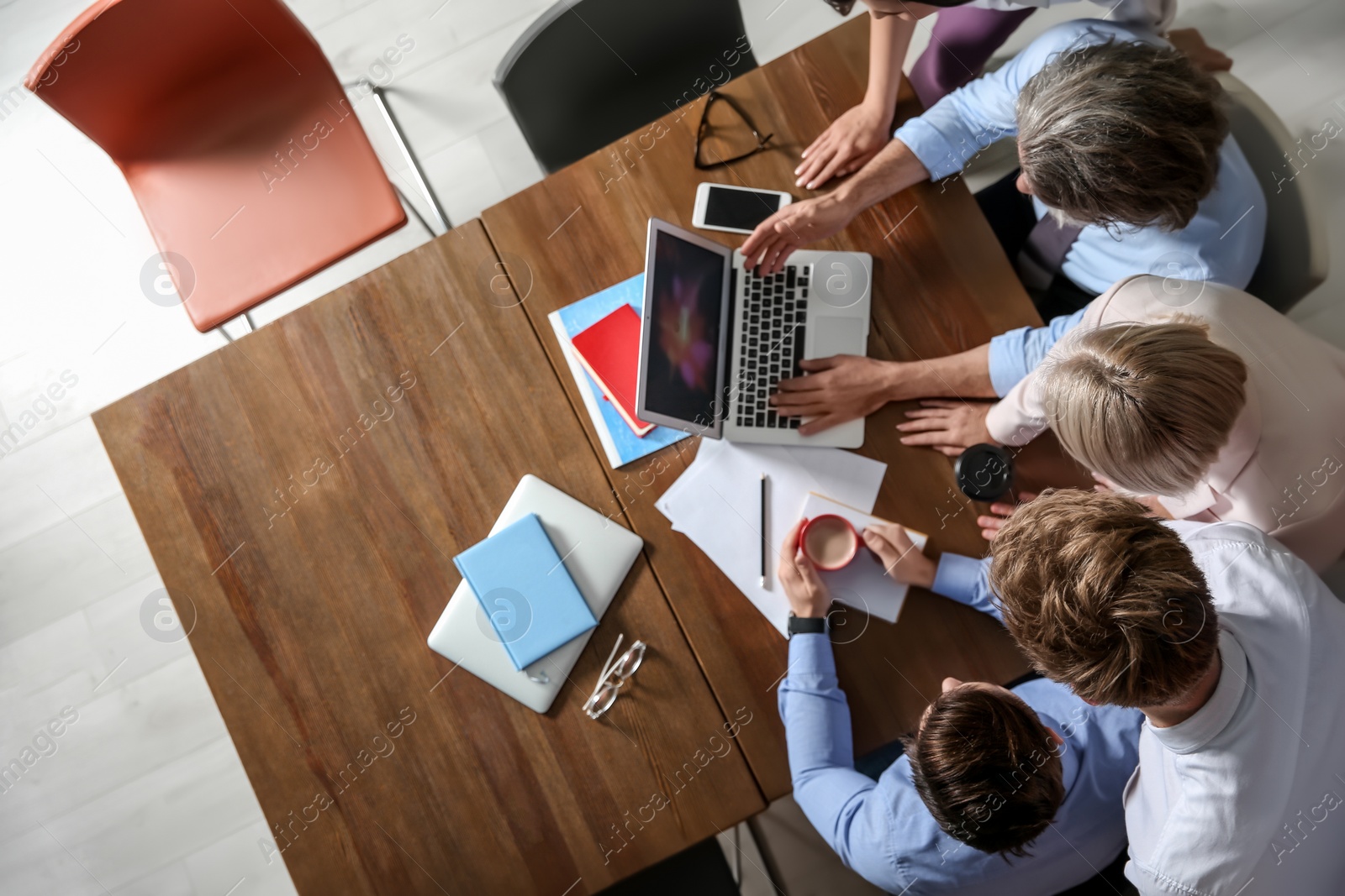 Photo of Business people discussing work matters at table in office, top view with space for text. Professional communication