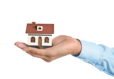 Real estate agent holding house model on white background