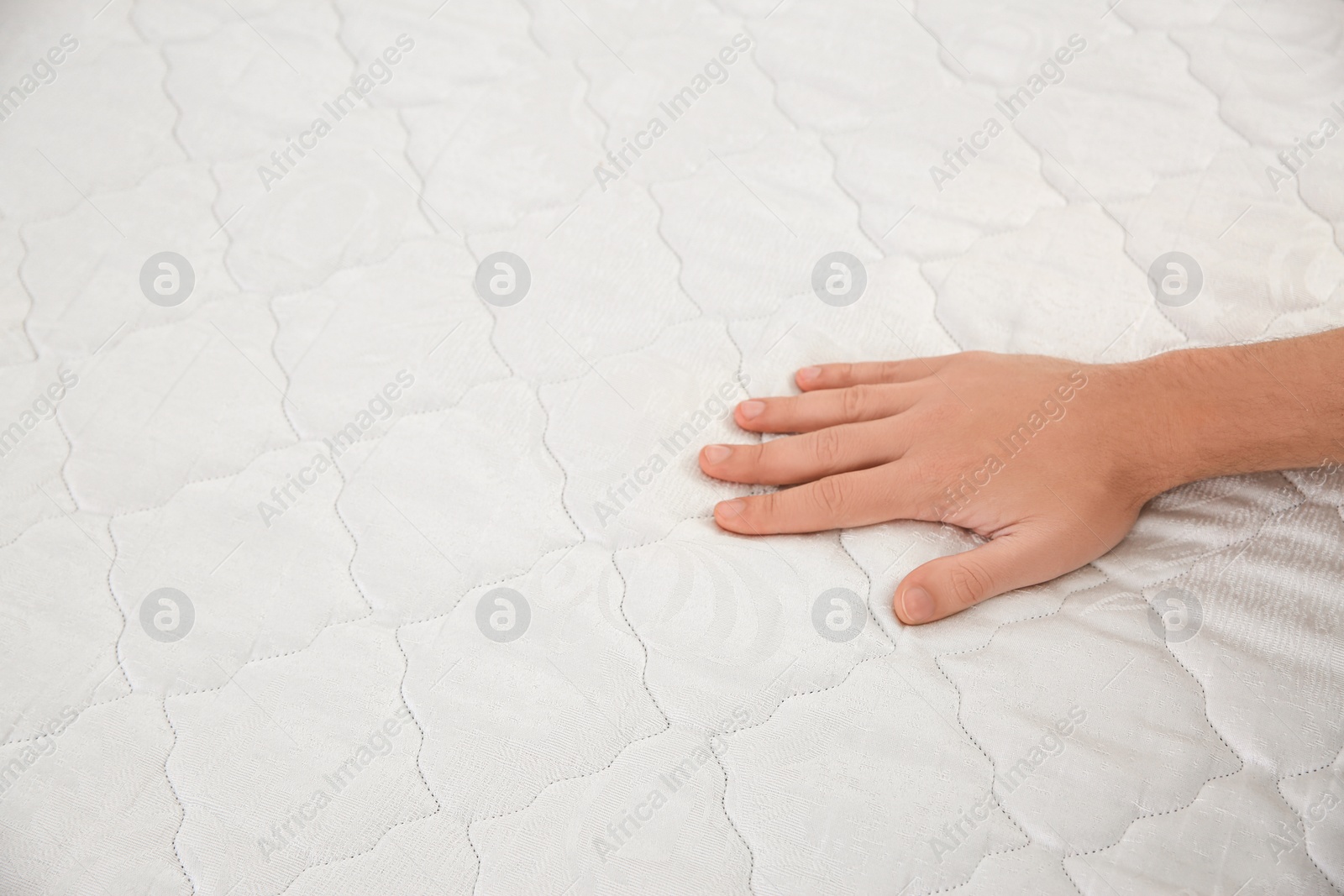 Photo of Man checking mattress firmness, closeup. Space for text