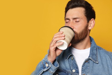 Photo of Bearded man drinking coffee on orange background. Space for text