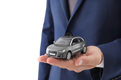 Photo of Insurance agent holding toy car on white background, closeup