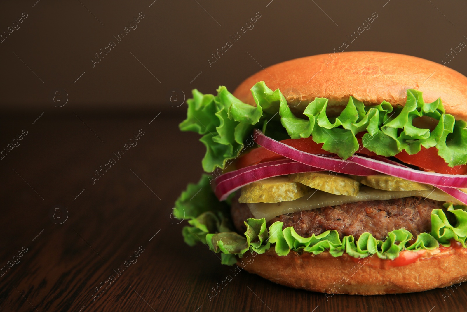 Photo of One tasty burger on wooden table, closeup. Space for text