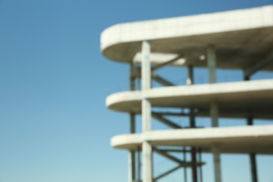 Photo of Blurred view of unfinished building against blue sky, space for text