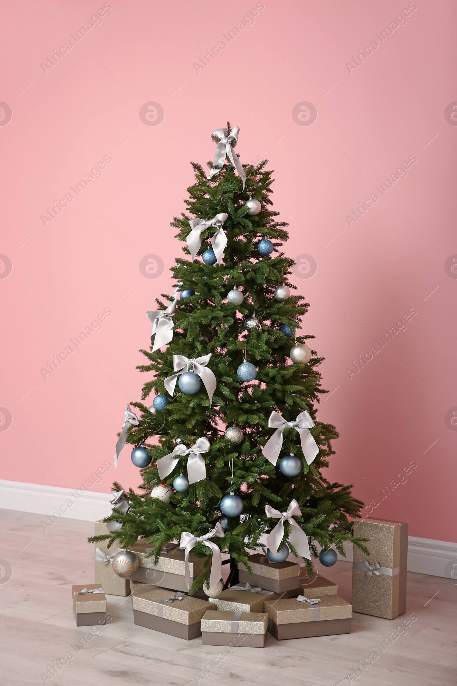 Photo of Decorated Christmas tree with gift boxes indoors