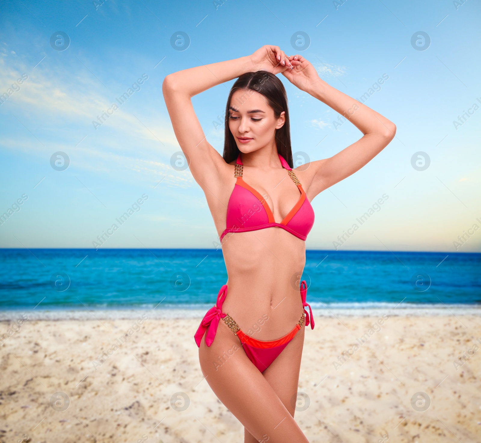 Image of Beautiful woman in stylish pink bikini on sandy beach near sea