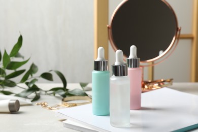 Photo of Bottles of cosmetic products on light grey table, space for text