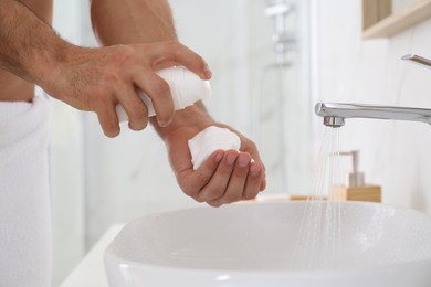 Photo of Man with shaving foam in bathroom, closeup