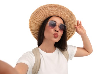 Photo of Smiling young woman in sunglasses and straw hat taking selfie on white background