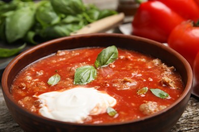 Photo of Bowl of delicious stuffed pepper soup on table, closeup