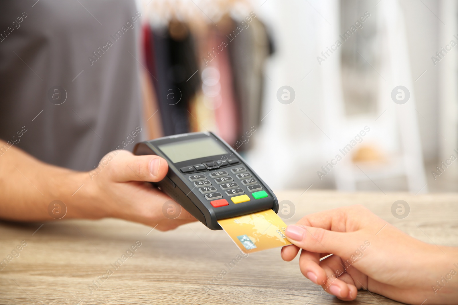 Photo of Woman using terminal for credit card payment in shop, closeup