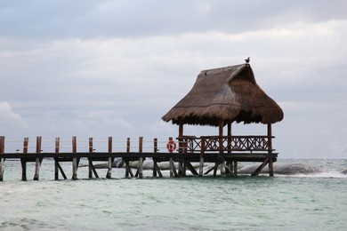 Photo of Wooden gazebo in sea on stormy weather