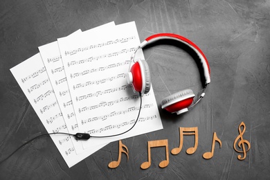 Photo of Flat lay composition with music notes and headphones on grey background