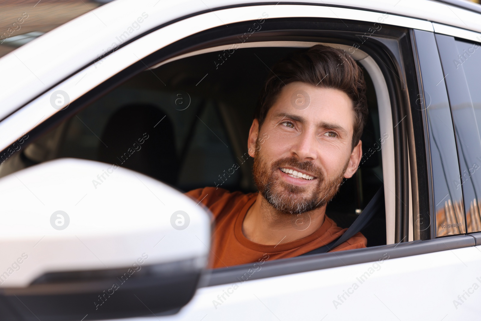 Photo of Happy man looking out of car window, view from outside. Enjoying trip