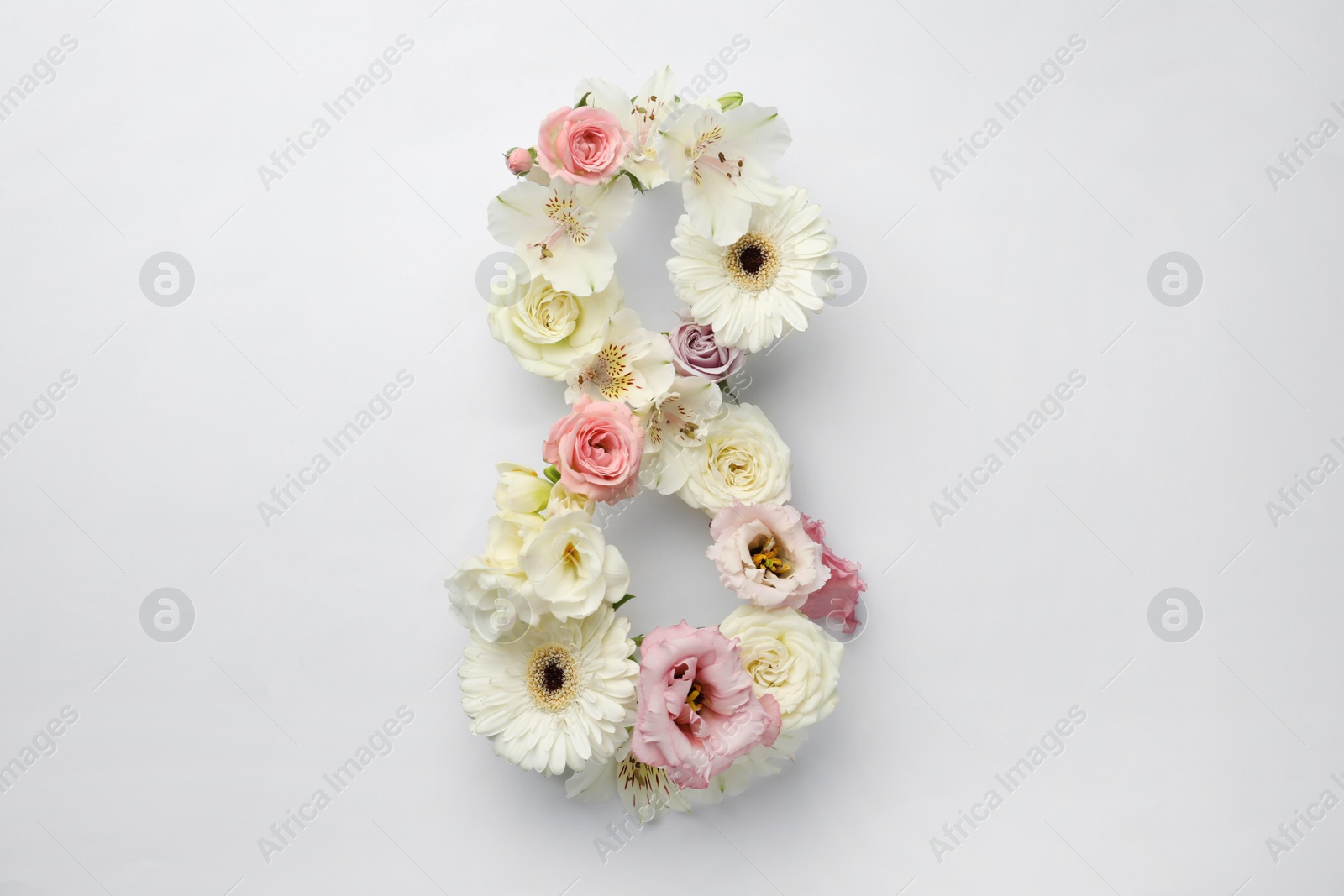 Photo of Number 8 made of beautiful flowers on white background, flat lay. International Women's day