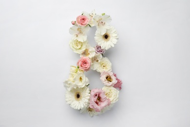 Photo of Number 8 made of beautiful flowers on white background, flat lay. International Women's day