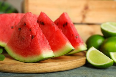 Photo of Slices of delicious watermelon and limes on light blue wooden table, closeup