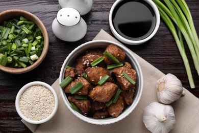 Photo of Tasty soy sauce, roasted meat and ingredients on wooden table, flat lay