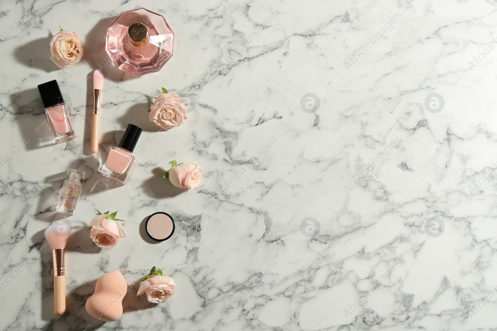 Photo of Flat lay composition with bottles of perfume, cosmetics and roses on marble background, space for text