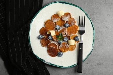 Cereal pancakes with blueberries and butter on light grey table, flat lay